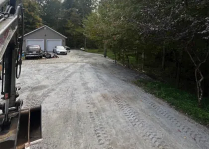 A finished gravel driveway running back through the woods.