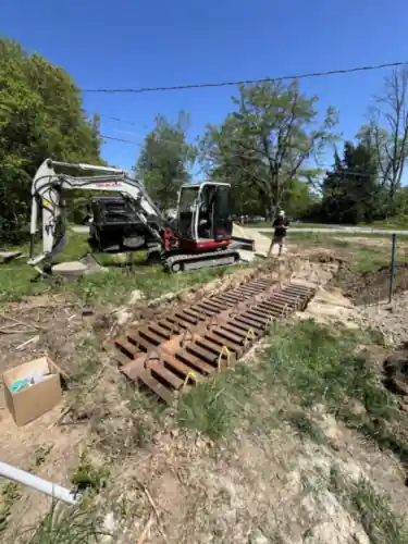 Leaching chambers laid out in an open trench with two excavators on site.