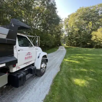 The Elevate Earth and Water Werks dump truck on a gravel drive.