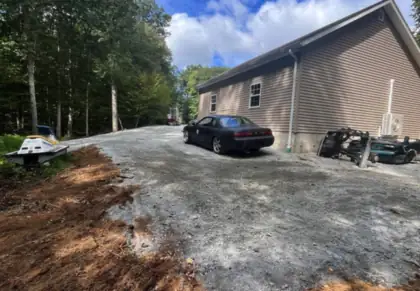 A driveway and turnaround finished beside a house.